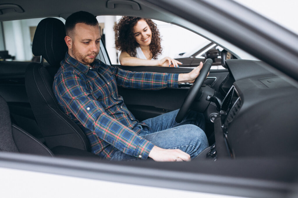 Driving instructor guiding a student during an in-car driving lesson for road test preparation