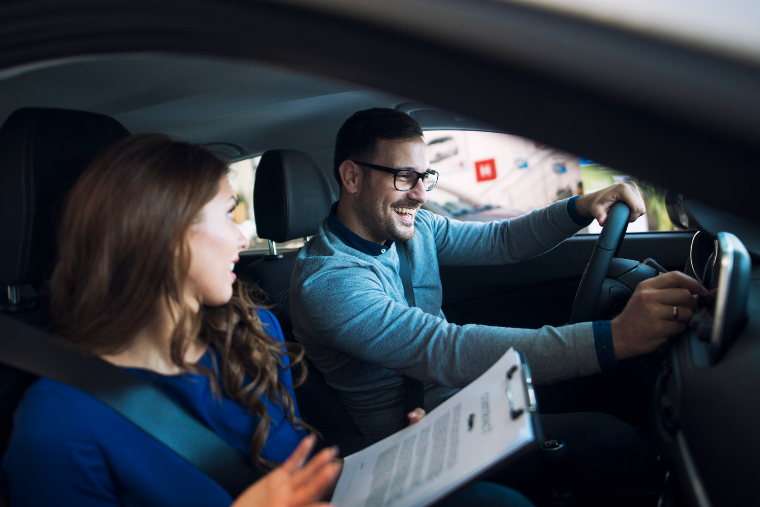 Professional driving instructor teaching a student during an in-car driving lesson