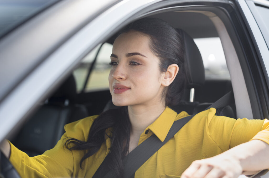 A confident young woman driving a car during her in-car driving lessons, preparing for her G2 driving test in Ontario.